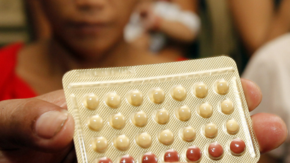 An NGO health worker holds contraceptive pills during a family planning session with housewives availing free pills in Tondo, Manila