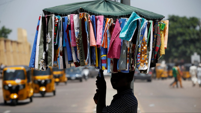 A man selling handkerchiefs walks along a street in Kano, Nigeria.