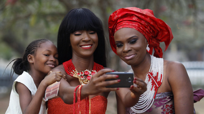 Models take selfies as they display neck beads, popularly used in social ceremonies, at a park in Ikeja duistrict in Lagos January 11, 2015.