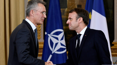 NATO Secretary General Jens Stoltenberg and French President Emmanuel Macron shake hands at the end of a news conference after their meeting at the Elysee palace in Paris