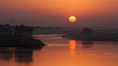 The sun sets over the Euphrates river in Raqqa.