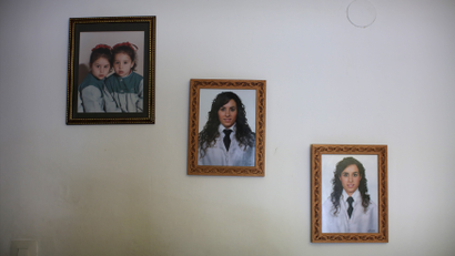 Photographs of two young Spanish nurses hang on the wall of their home