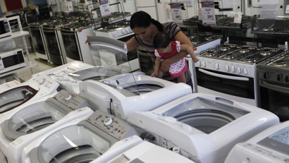 A woman and her daughter look at a washing machine at a Casas Bahia store in Sao Paulo