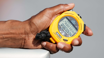 An outstretched hand holds a stopwatch