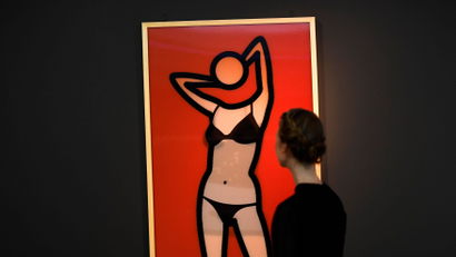 A museum worker poses as she looks at a lenticular print during a media event to promote 'Undressed: A Brief History of Underwear' at the V&amp;A Museum in London