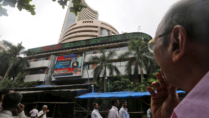 Man watches large screen displaying India's benchmark share index on the facade of BSE building in Mumbai