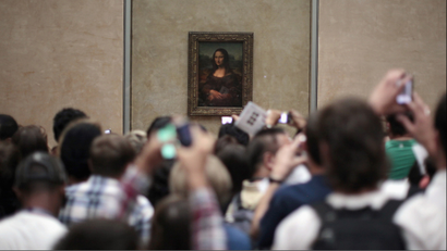 People view Leonardo da Vinci's painting of the Mona Lisa at the Louvre museum in Paris July 16, 2011. REUTERS/Lucy Nicholson