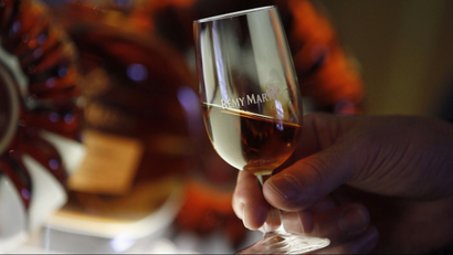 An employee holds a glass of cognac at the Remy Martin distillery in Cognac, southwestern France, October 8, 2012. As overall cognac sales have recovered from the 2008/09 downturn, discerning Chinese looking for an aspirational tipple are causing a surge in shipments of Remy Martin's 2,500-euro Louis XIII cognac and other deluxe spirits. The trend is good news for Remy Martin, which is much more focused than its rivals on high-end brands, and suggests that a slowdown in China's overall economic growth rate may not dampen the country's appetite for some luxury goods, even if some sectors have sounded warnings. To match Feature COGNAC-REMY/ Picture taken October 8, 2012. REUTERS/Regis Duvignau