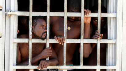 Migrants look out of a barred door at a detention center in Gharyan, Libya October 12, 2017.