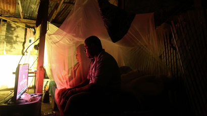 Julian and his wife Zulma watch television powered with the help of a generator after Hurricane Maria damaged the electrical grid in September, in Dorado