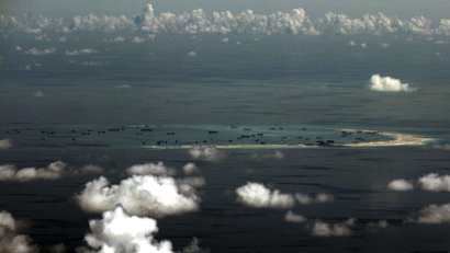An aerial photo taken though a glass window of a Philippine military plane shows land reclamation by China around the Spratly Islands in the South China Sea.