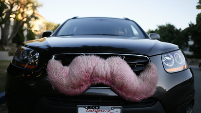 A driver with the ride-sharing service Lyft waits for a customer on a street in Santa Monica, California
