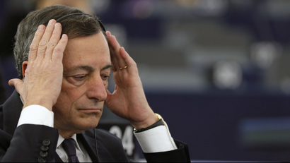 European Central Bank President Mario Draghi adjusts his earphones as he attends a debate on the ECB Annual Report