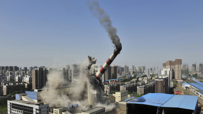 The provincial highest chimney collapses as it is demolished by explosives in Shenyang, Liaoning province, April 28, 2014. The 150-metre-high chimney used to be part of a local heating factory, according to local media. china fiscal stimulus spending real estate property housing collapse