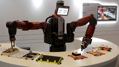 A Baxter robot of Rethink Robotics picks up a business card as it performs during display at the World Economic Forum, in China's port city Dalian