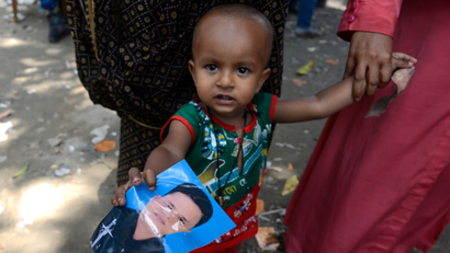Bangladeshi boy holds photo of father
