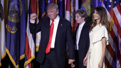 President-elect Donald Trump pumps his fist after giving his acceptance speech as his wife Melania Trump, right, and their son Barron Trump follow him during his election night rally, Wednesday, Nov. 9, 2016, in New York.