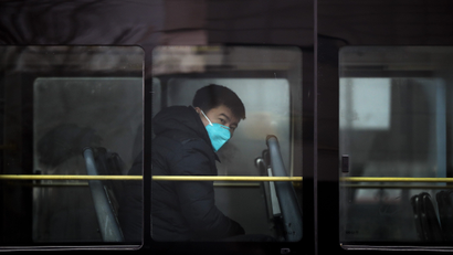A man wearing a mask for protection against air pollution looks out from a bus in Beijing as the capital of China is shrouded by heavy smog on Tuesday, Dec. 20, 2016. Thick, gray smog fell over Beijing on Tuesday, clouding China's capital in a haze that spurred authorities to cancel flights and close some highways in emergency measures to cut down on air pollution. (AP Photo/Andy Wong)