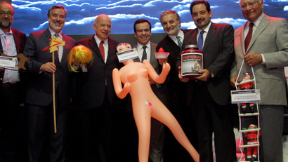 Chile's economy minister Luis Cespedes holds up an inflatable doll during an event of the exporters' association Asexma in Santiago