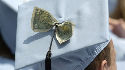 a mortarboard with a dollar bill tucked inside it