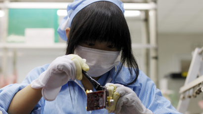 An employee works along a production line in Suzhou Etron Electronics Co. Ltd's factory in Suzhou