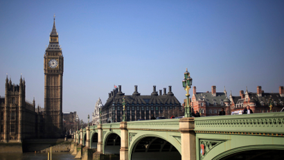 Pedestrians walk across Westminster Bridge in front of the Big Ben Clock Tower