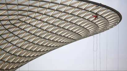 A migrant construction worker cleans the exterior of the "Sunny Valley", a structure to harness solar energy, at the 2010 Shanghai World Expo site in Shanghai, in this January 6, 2010 file photo. So far, wind turbines are not Sputnik. But one day they could be. The global race to develop clean technology is not just about who can build the best solar parks or wind farms. It is also shaping up as a contest between Chinese-style capitalism and the more market-oriented approach fancied by the United States and Europe. To match special report DAVOS/GREEN REUTERS/Nir Elias/Files
