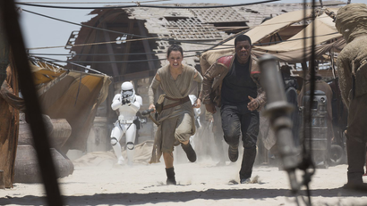 Rey and Finn from Star Wars run from a Stormtrooper