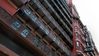 view from below of a multi-story hotel with balconies and the word HOTEL written out in red letters vertically along the sisde