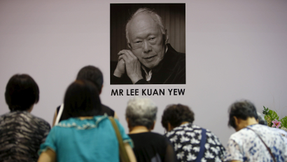 People bow in front of a coffee of Lee Kuan Yew
