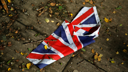 A British flag which was washed away by heavy rains the day before lies on the street in London