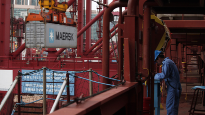 A crew member works as cargo is unloaded from Emma Maersk, one of the world's largest containers.