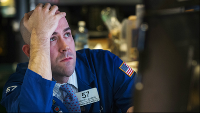 A trader watches the screen at his terminal on the floor of the New York Stock Exchange