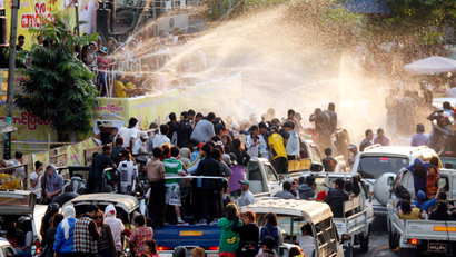 Vehicles carrying revelers line up towards a pavilion sprayed water during the traditional Thingyan celebrations in Yangon, Myanmar, Sunday, April 14, 2013. Myanmar celebrated its annual water festival, known as Thingyan, from Saturday, marking the start of the New Year according to the traditional Buddhist calendar.