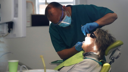 A dentist tends to a patient in Milton Keynes, UK, following the outbreak of the coronavirus disease.