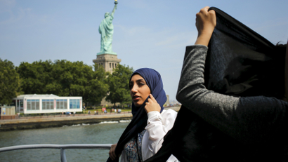Woman in a hijab near the Statue of Liberty.