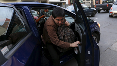 Lyft rider Adam Subiaga exits a car during a photo opportunity in San Francisco