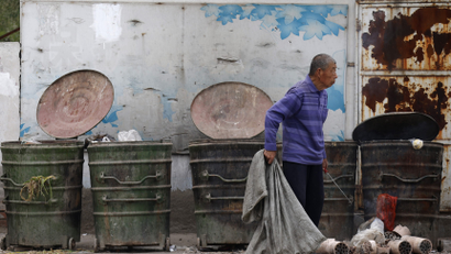 A garbage collector rummages through trash cans to find recyclable garbage at a residential area for migrant workers in Beijing May 7, 2013. For two decades, Chinese local governments have been able to ignore the problem of housing migrants, thanks to the makeshift villages and other arrangements that accommodate about 40 percent of migrants.China has pledged to double household incomes over the coming decade in a bid to close a wealth gap so wide it threatens social stability. Although the proportion of extreme poverty has fallen over recent decades, about 12 percent of the country's 1.3 billion people still live on less than $1.25 per day, according to a 2013 United Nations report. Picture taken on May 7, 2013. REUTERS/Kim Kyung-Hoon (CHINA - Tags: BUSINESS SOCIETY WEALTH) - GM1E99513CW01