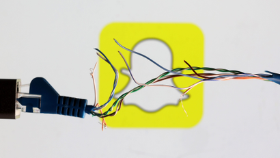 A broken ethernet cable with frayed wires crosses in front of the Snapchat logo.