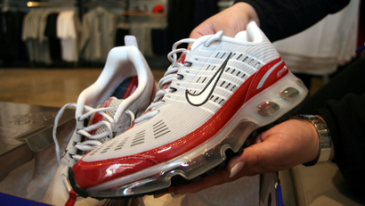 A salesperson pulls out a pair of Nike Air Max 360 running shoes for a customer in the Niketown in a downtown Denver file photo from March 21, 2006.