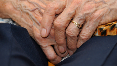 An old person clasping their hands
