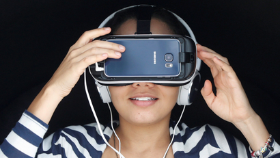 A woman demonstrates a Samsung virtual reality unit.
