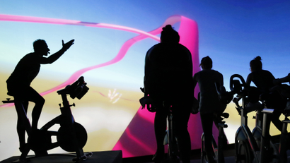 an image of a spin class happening in front of abstract art