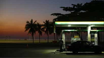 A worker prepares to fill a car at a gas station close to Copacabana beach in Rio de Janeiro, January 12, 2015.