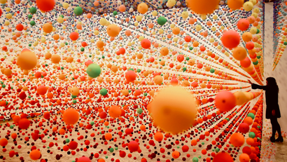 Nike Savvas adjusts her installation artwork piece, consisiting of over 50,000 polystyrene balls, titled 'Atomic: full of love full of wonder' as it is installed at the New South Wales Art Gallery in Sydney.