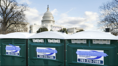 Three port-a-potties outside of the US Capitol. The logo of their company—Don's John's—has been covered with blue tape.