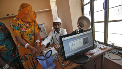 A villager goes through the process of a fingerprint scanner to register for the Unique Identification (UID) database system at an enrolment centre at Merta district in the desert Indian state of Rajasthan