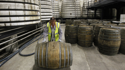 A technician rolls an oak barrel in a cellar where cognac is aged at the Remy Martin distillery in Cognac, southwestern France.