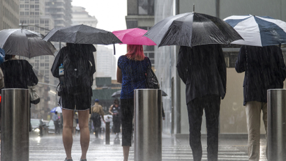People use umbrellas as a downpour of rain falls during the afternoon rush hour in New York