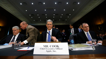 Apple CEO Tim Cook (C), CFO Peter Oppenheimer (L) and Apple Head of tax operations Philip Bullock appear before a Senate homeland security and governmental affairs investigations subcommittee hearing on offshore profit shifting and the U.S. tax code, on Capitol Hill in Washington, May 21, 2013. Apple Inc came under fire on Tuesday at a Senate hearing over an investigation that alleged the U.S. high technology icon has kept billions of dollars in profits in Irish subsidiaries and paid little or no taxes to any government.